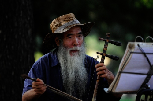 Old Man playing traditional music in a public park
